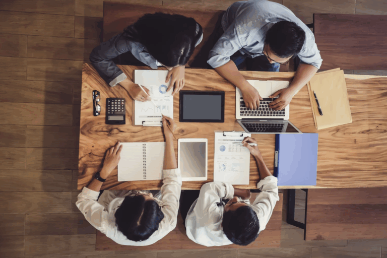 A business meeting in a modern office space with three individuals.
