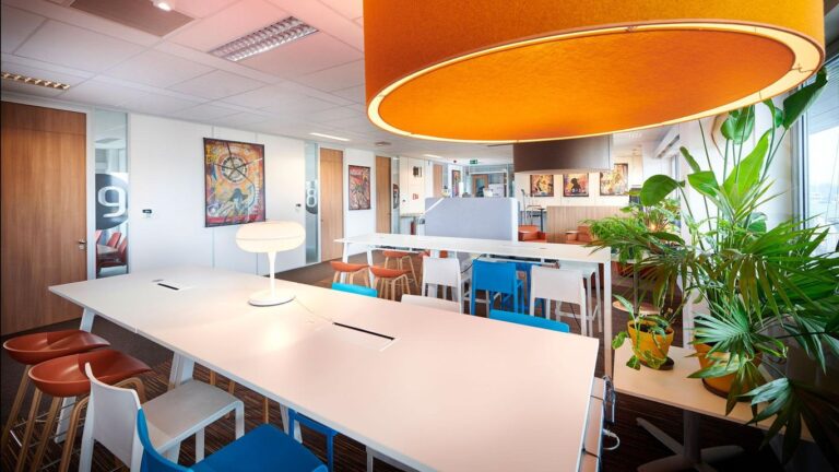 Bright office space with colorful furniture and large lamps.