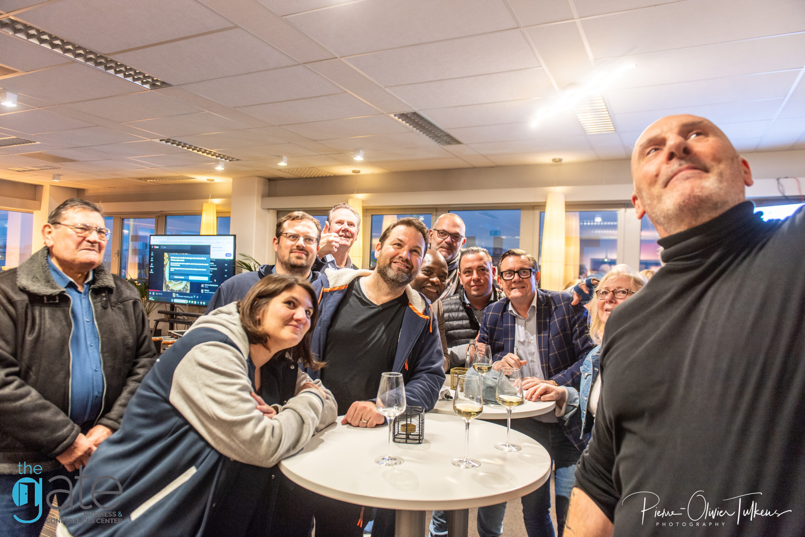 Group of people gathered around a table, smiling and socializing.